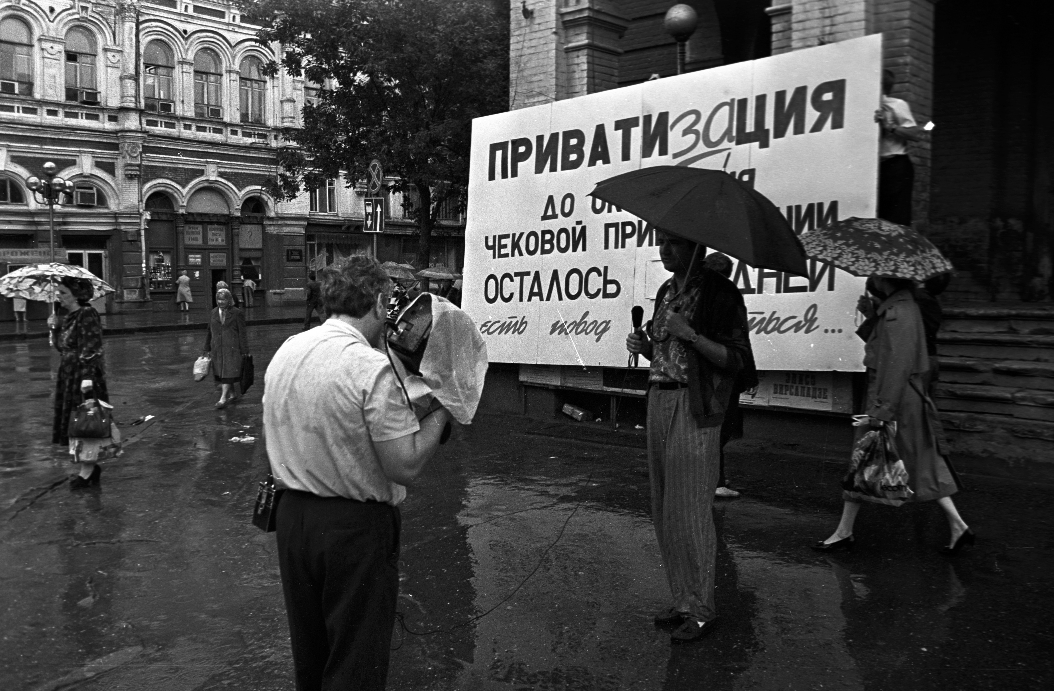 Тележурналисты работают у информационного стенда об окончании чековой приватизации. 1994 г. Фото: Николай Титов / Квадра Медиа / PhotoXPress. https://n1s1.hsmedia.ru/3f/0c/00/3f0c00e4a815a4a3091f00be43fdeadf/3699x2425_0xac120003_13782201431664620361.jpeg