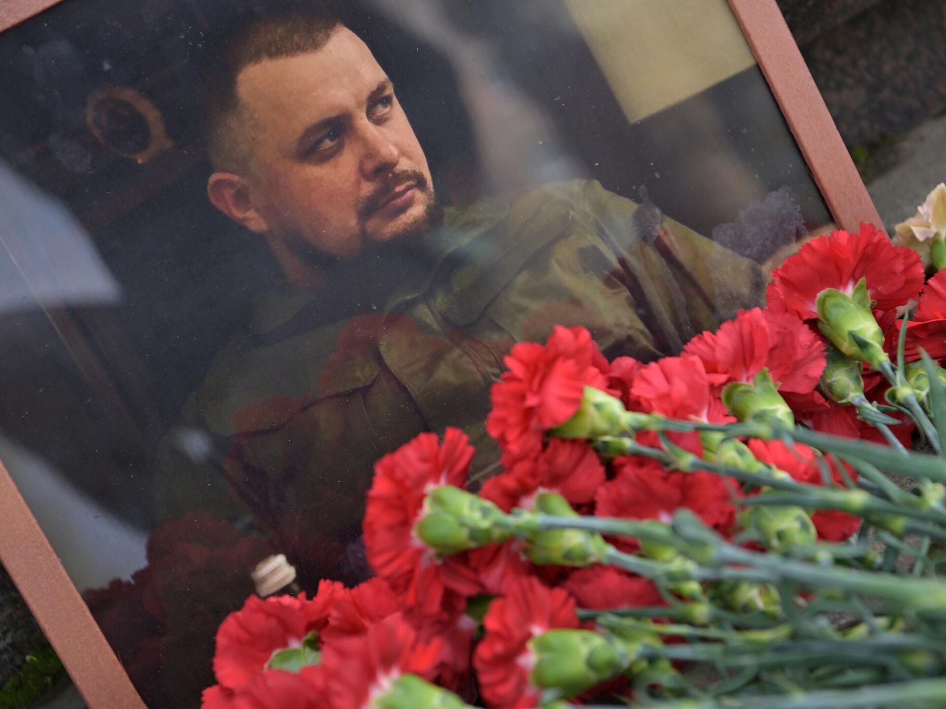 Стихийный мемориал на набережной у кафе в Санкт-Петербурге, где погиб военный корреспондент Владлен Татарский. 2023 г.